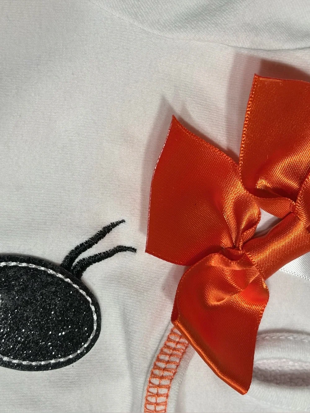 Cutie Halloween costume Has orange, black, and white tulle skirt and wrists.